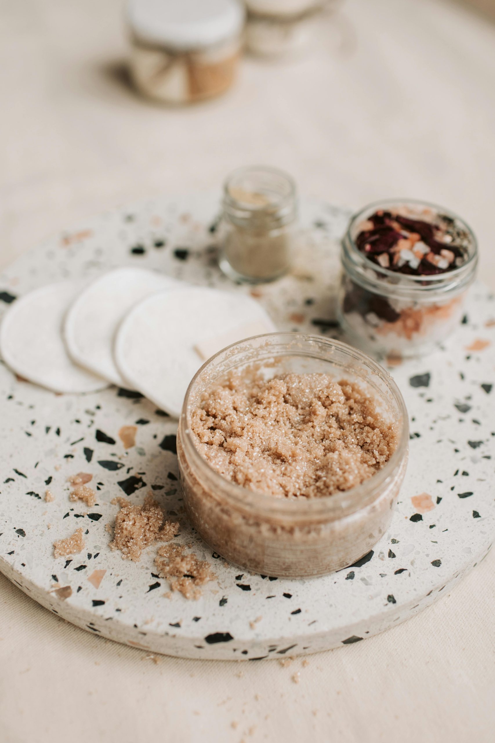 Flat lay of natural scrub and cotton pads for eco-friendly skin care routine.